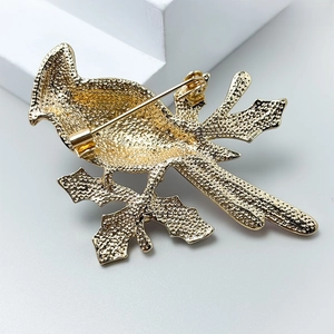 Detail view of the back of bird brooch with golden plating and secure metal pin clasp