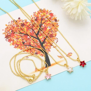 Detailed close-up of colorful star crystal pendants on dainty gold beaded necklaces