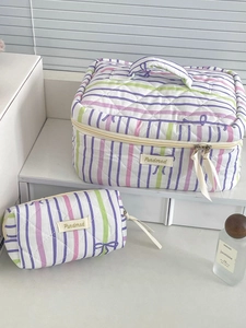 Detailed view of quilted cotton makeup bags with purple stripes and bow patterns