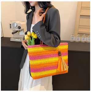 Close-up of rainbow woven beach tote featuring colorful stripes and stylish tassel detail
