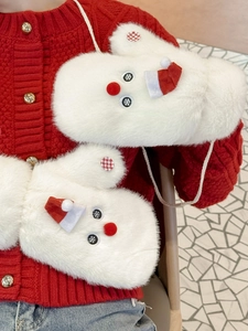 Close-up of white plush snowman gloves with red hat and neck string for winter