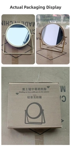 Detail view of round gold desktop makeup mirror with rotating metal frame and gift box