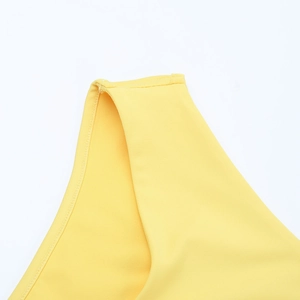 Détail de la robe jaune tricotée montrant les coutures de qualité et la texture côtelée