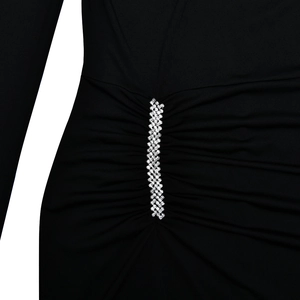 Detail of black slim-fit dress featuring side pleats and elegant rhinestone embellishments