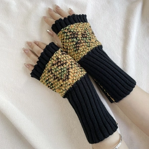 Close-up of knit fingerless gloves with colorful butterfly pattern and wool texture