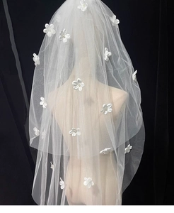 Detail of bridal white mesh veil featuring 3D flowers and delicate pearl centers