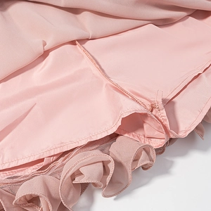 Close-up of pink chiffon dress showing high-quality stitching and mesh ruffle layers