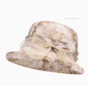 Detail of light khaki sun hat featuring organza bow and intricate leaf jacquard pattern