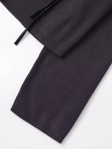 Detail of dark grey ribbed knit fabric with drawstrings and textured cuffs on casual garment