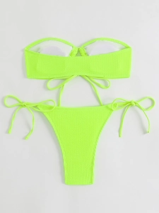Flat lay of neon green ribbed tube top bikini set with side-tie bottoms on grey backdrop