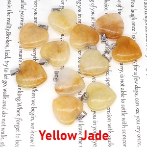 Détail macro de pendentifs en jade jaune naturel en forme de cœur avec fermoirs en argent
