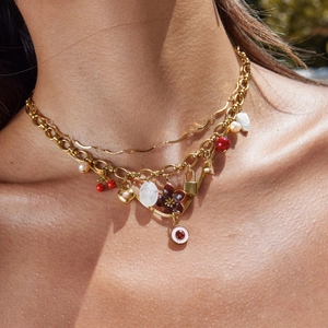 Layered 18K gold stainless steel necklace with red cherry, pearl and lock charms on model