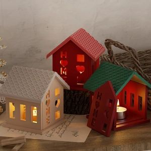 Close-up of HOME house-shaped candle holders with heart cutouts in cozy setting