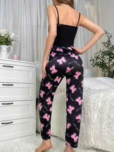 Close-up of black pajama pants with pink bow patterns and good night script text