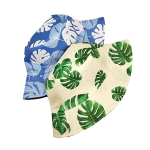 Detail of reversible bucket hats featuring blue and beige tropical leaf floral prints