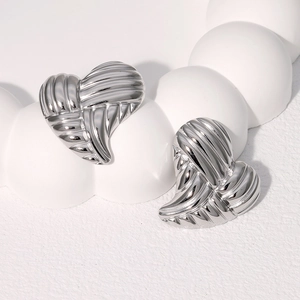 Vue détaillée de boucles d'oreilles cœur argentées avec surface texturée métallique