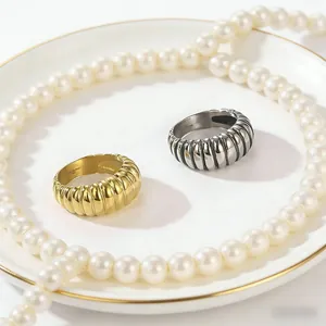 Detail showing gold and silver croissant-style stainless steel rings with pearls