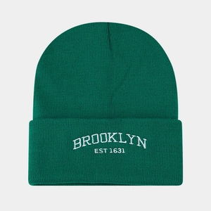 Detail of white Brooklyn embroidery on a dark green ribbed knit beanie hat