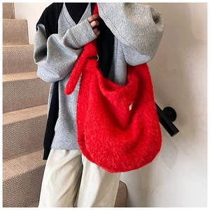 Detail of soft red faux fur tote bag showing plush texture and stylish knotted shoulder strap