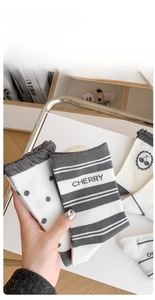 Gros plan de chaussettes en coton avec broderie cerise et détails de bords-côtes