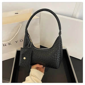 Detail of black crocodile texture handbag with matching card holder and unique handle