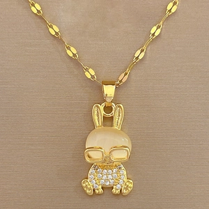Macro shot of gold rabbit necklace with cat eye stone head and pavé zircon details