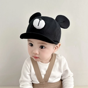 Close-up of soft black baby baseball cap with white bear face and 3D ear details