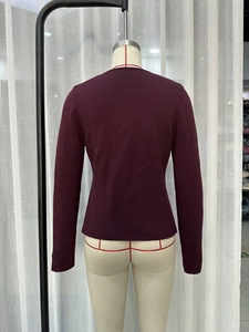 Detailansicht der Rückseite der weinroten Strickjacke mit Rippenstruktur und engem Schnitt