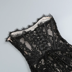 Détail d'un corset en dentelle noire avec motifs floraux et laçage au dos de la robe