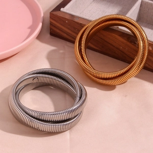 Detail of gold and silver triple-layered flexible snake chain bangles in stainless steel