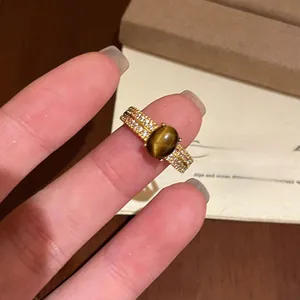 Dettaglio anello placcato oro con pietra occhio di tigre ovale e zirconi pavé