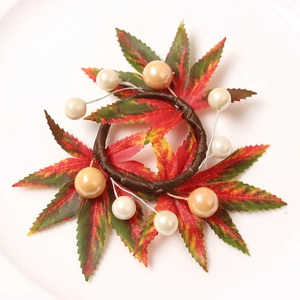 Close-up of Christmas napkin ring with red berries, pine cones and maple leaf decor