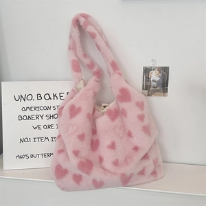 Detail of soft pink faux fur tote bag with red heart pattern and plush texture