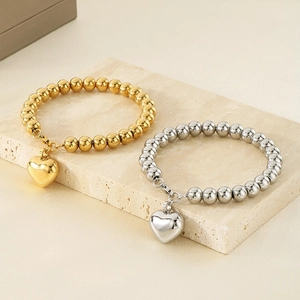 Bracelets à billes dorés et argentés polis avec pendentifs cœur sur une pierre