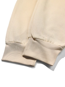 Dettaglio dei polsini a coste ad alta densità su una tuta in pile color beige