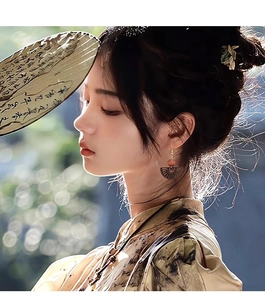Detail of wooden fan-shaped earring with carved texture and bead on a model