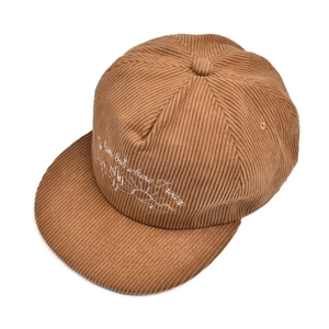 Macro shot of brown corduroy fabric and cursive embroidery on a vintage flat brim baseball cap