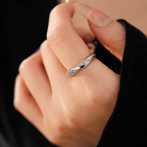 Close-up of twisted silver ring with pave-set micro zircons on a model hand
