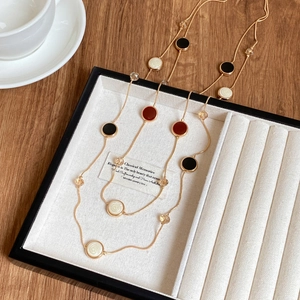 Detail of double-layer gold necklace with multi-colored enamel pendants and faceted beads