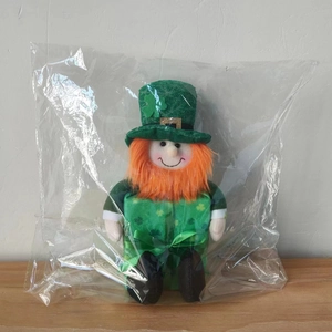 Detail of St. Patrick's Day leprechaun plush doll in protective plastic packaging