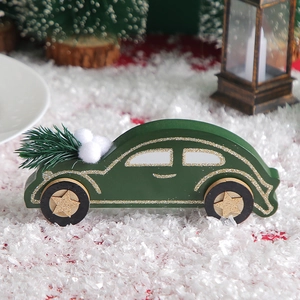 Dark green wooden car Christmas ornament with gold glitter and snow scene background