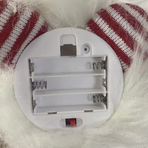 Detail view of the battery compartment and power switch for the glowing Christmas doll