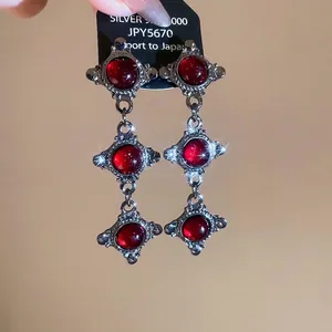 Vintage silver-toned triple drop cross earrings featuring oval red resin gemstones