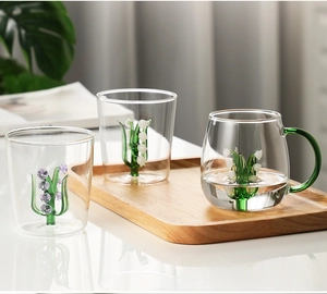 Detailed close-up of handmade glass cups with 3D lily of the valley floral inside the base