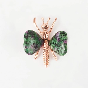 Detailed view of butterfly ornament with rose gold frame and green purple crystal wings