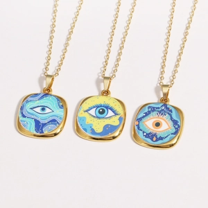 Detailed view of three vintage-style golden square enamel evil eye charms in blue and orange