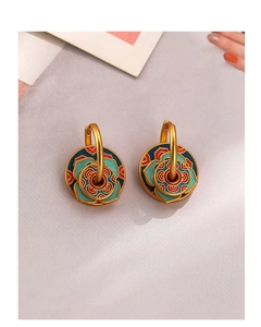 Detailed close-up of retro enamel earrings with colorful pattern and golden base
