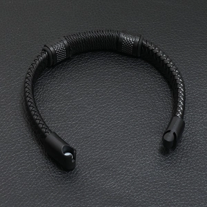 Detailed macro view of black braided leather strap with secure magnetic metal clasp closure