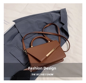 Top-down view of brown litchi pattern leather bag on gray suit and pleated fabric