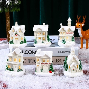 Close-up of 6 white resin Christmas village miniatures including a train station on snow